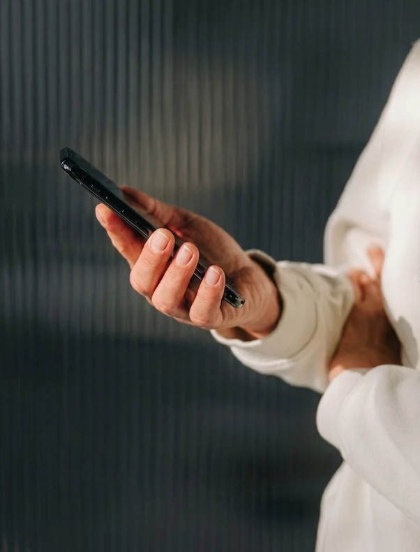 A person checking their phone behind ribbed glass